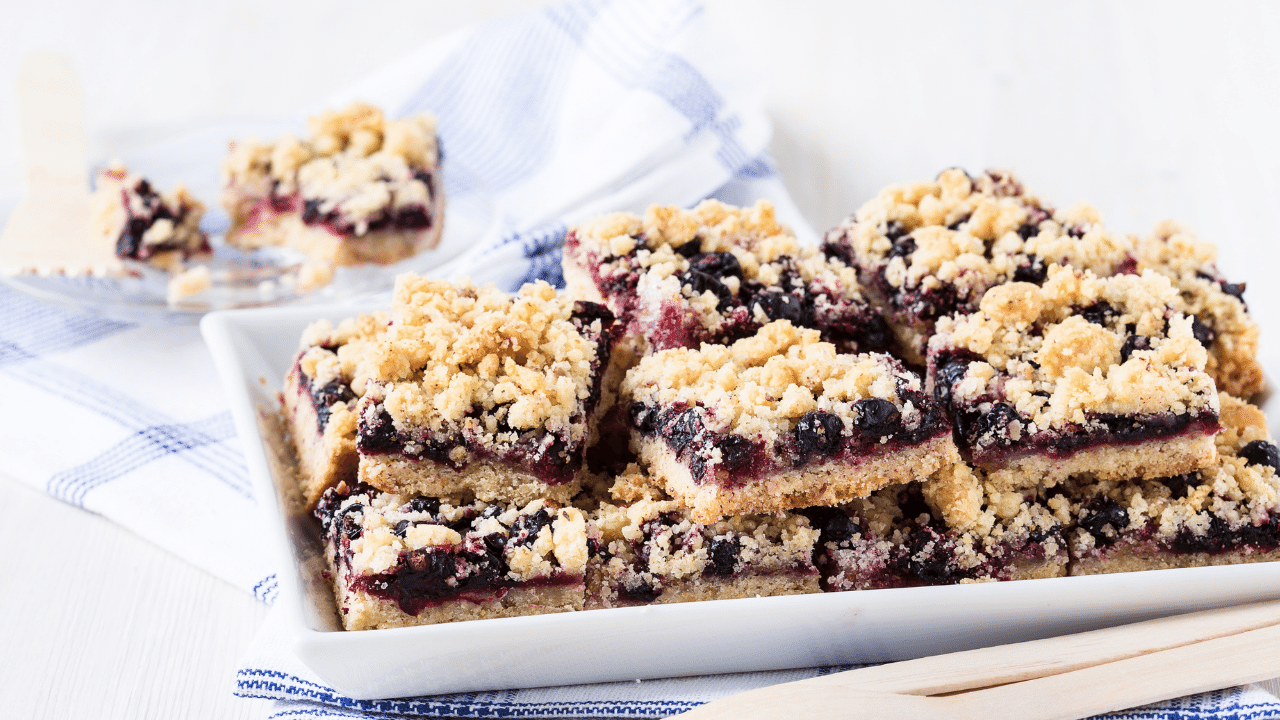a plate of blueberry bars with crumble topping, blueberry crumble bars